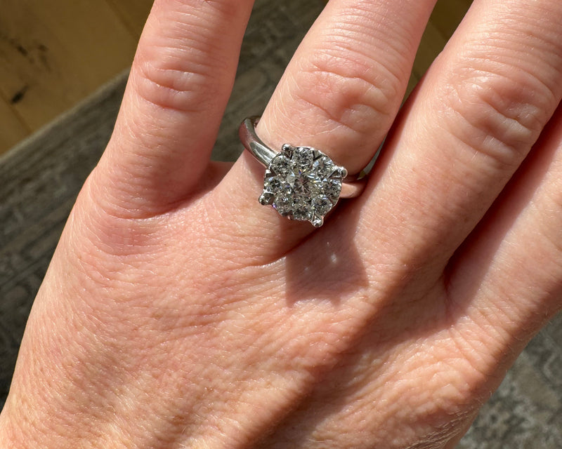 Hand wearing a diamond ring with a blurred background